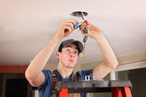 Electrician installing a ceiling fan